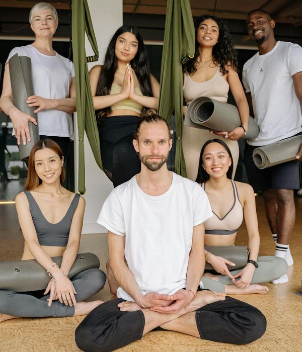Diverse group of people smiling during a yoga class.